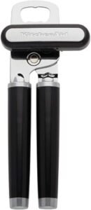 Black KitchenAid manual can opener with ergonomic handles and cutting wheel.